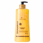 Botella de champú profesional de argán de Natural Center, 900 ml. Formulado para fortalecer y dar volumen al cabello, ideal para restaurar la salud capilar. Su presentación incluye un dispensador para facilitar su uso. Perfecto para quienes buscan un tratamiento nutritivo y reparador para el cabello.
